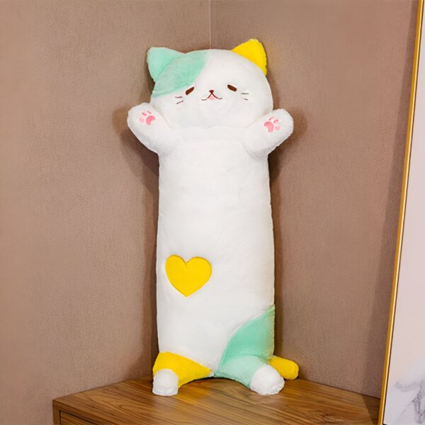 Un oreiller en forme de chat blanc avec un cœur jaune sur le ventre, les pattes et les oreilles en couleur pastel.