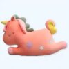 Une licorne rose en peluche avec une crinière verte, une queue jaune et des étoiles sur son corps.