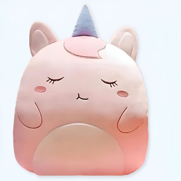 Une licorne en peluche rose avec des yeux fermés et une corne bleue.