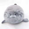 peluche-oreiller-phoque-doux-et-adorable-pour-enfant-2a-5 Un gros phoque en peluche gris avec de grands yeux noirs et une bouche rose.