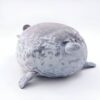 peluche-oreiller-phoque-doux-et-adorable-pour-enfant-8a-1 Un phoque en peluche gris et blanc allongé sur le ventre.