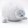 peluche-oreiller-phoque-doux-et-adorable-pour-enfant-9a-1 Un gros phoque gris et blanc allongé sur le dos, les yeux fermés.