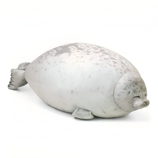 Une peluche de phoque gris allongé sur un fond blanc.