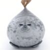 Un gros coussin en forme de phoque gris avec un visage mignon.