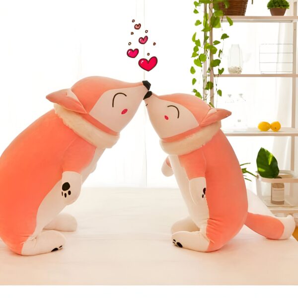 Deux peluches renards roses se font face, se tenant la tête et entourées de cœurs roses.