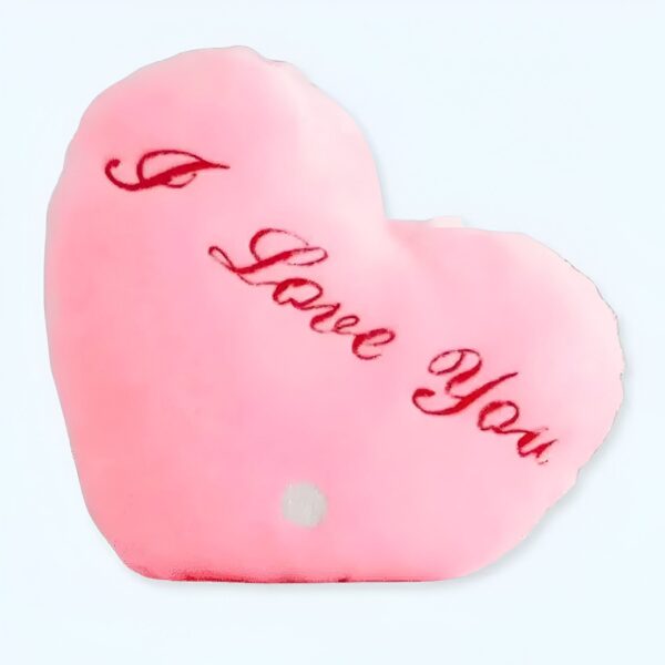 Un coussin en forme de cœur rose avec l'inscription "I Love You" en rouge.
