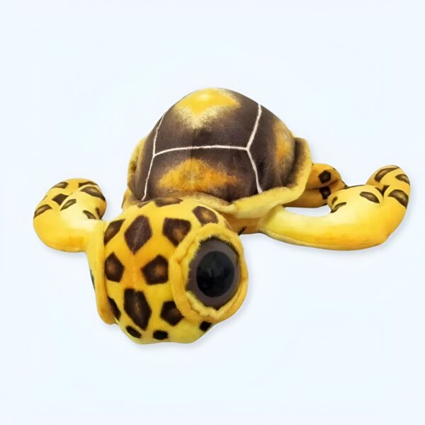 Une tortue en peluche jaune et brune avec de grands yeux noirs.