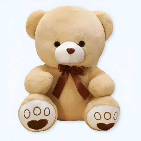 Ours en peluche beige assis avec un nœud brun. Il a des yeux noirs et un nez brun. Ses pattes ont des détails en forme de cœur.