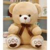 Un ours en peluche beige assis avec un nœud brun.