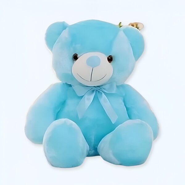 Ours en peluche bleu assis avec un nœud bleu.