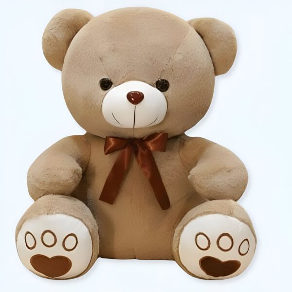 Un ours en peluche brun assis avec un nœud brun. Il a des yeux noirs, un nez rouge et des pattes blanches avec des empreintes brunes.