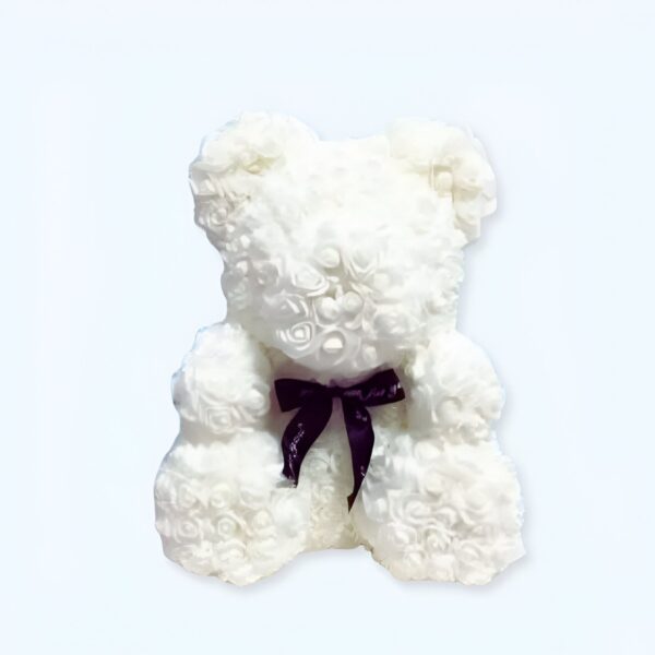 Ourson en peluche blanc fait de roses, avec un nœud noir.