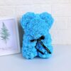 Ours en peluche bleu fait de roses artificielles avec un ruban noir autour du cou.