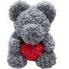 Ours en peluche fait de roses grises tenant un cœur rouge.