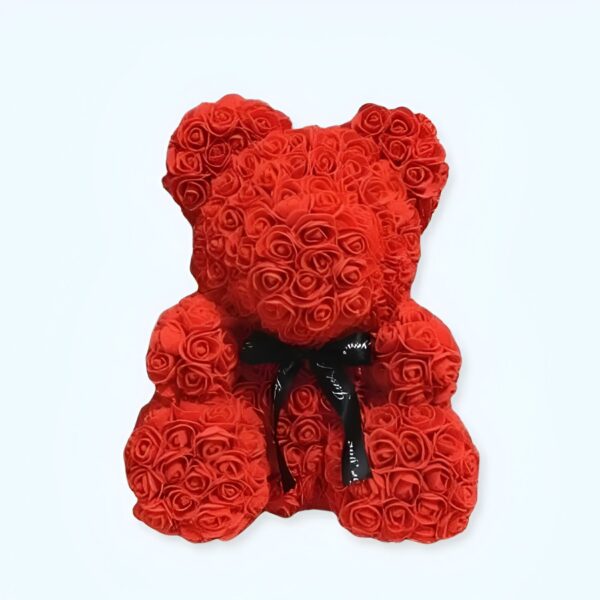 Ours en peluche rouge fait de roses artificielles avec un ruban noir.