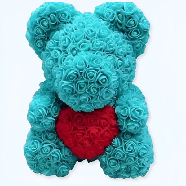 Ours en peluche bleu turquoise fait de roses artificielles tenant un cœur rouge en roses artificielles.