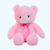 Un ours en peluche rose assis avec un nœud rose autour du cou.