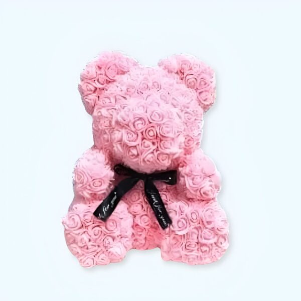 Ours en peluche rose fait de roses artificielles avec un nœud noir.