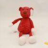 Une peluche rouge et blanche en forme d'ours avec une étiquette blanche.