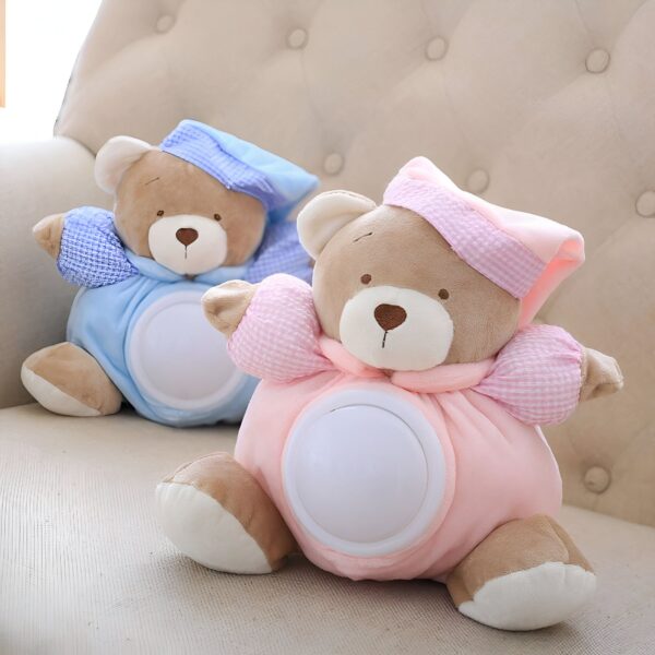 Deux ours en peluche, l'un bleu et l'autre rose, avec une lumière intégrée dans leur ventre. Ils portent un bonnet et sont assis sur un fauteuil.