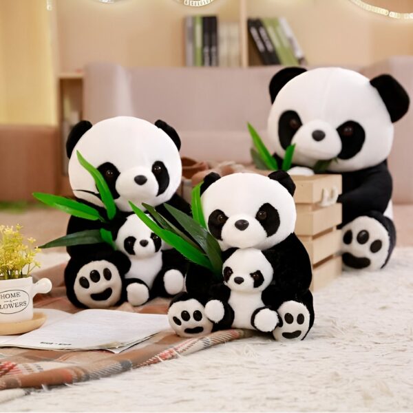 Une famille de quatre peluches pandas, assises sur un tapis avec du bambou vert. La plus grande panda tient un morceau de bambou dans sa bouche.