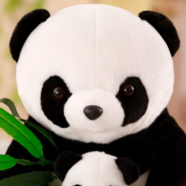 Un gros ours en peluche panda noir et blanc tient un petit ours en peluche panda.