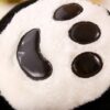Une patte de panda en peluche avec des détails noirs brillants.
