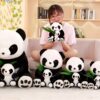 Une jeune femme souriante tient un grand ourson en peluche panda noir et blanc, il y a aussi cinq autres oursons panda plus petits sur le canapé avec elle.