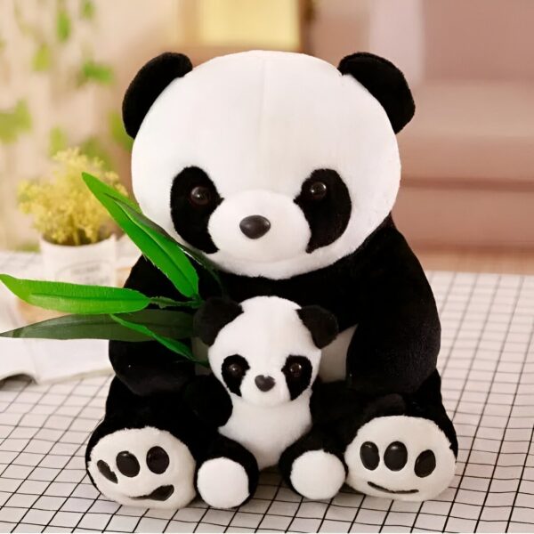 Deux peluches de panda, l'un plus grand que l'autre, assis ensemble, tenant des feuilles de bambou vertes.