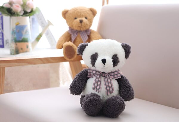 Un adorable ours en peluche panda assis sur un fauteuil avec un ours en peluche brun derrière lui.