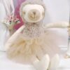 Une peluche de paresseux portant une jupe de tulle beige.