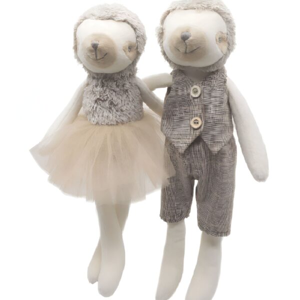 Deux peluches de paresseux tenant la main, une fille en tutu et un garçon en veste.
