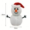 Bonhomme de neige en peluche blanc avec un chapeau rouge et des bras noirs, mesurant 20 cm de haut et 12 cm de large.