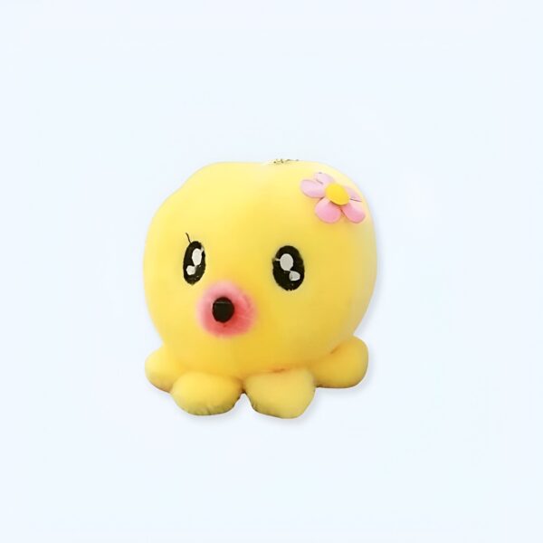 Une adorable petite pieuvre en peluche jaune avec une fleur rose sur la tête.