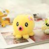 Une peluche jaune en forme de poulpe avec des yeux noirs et une fleur rose sur la tête, posée sur un livre.
