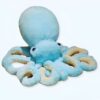 Grande pieuvre en peluche bleu clair avec des yeux noirs et des tentacules beiges.
