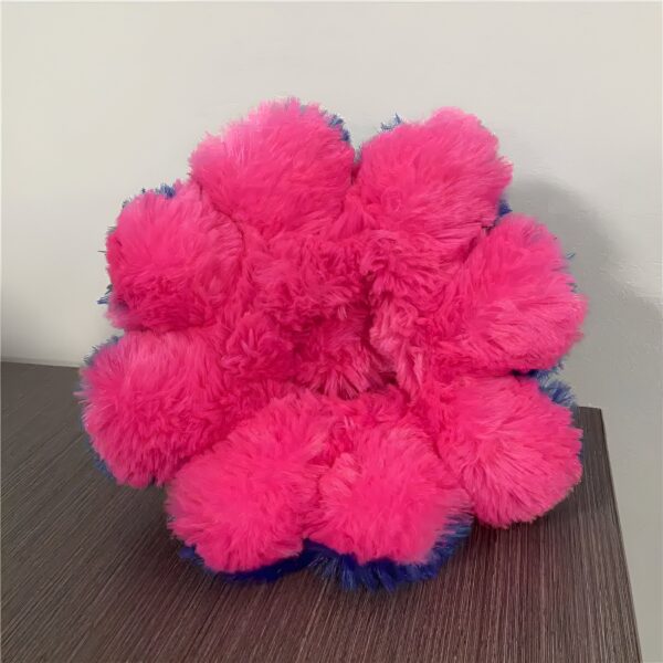 Coussin moelleux rose et bleu en forme de fleur.