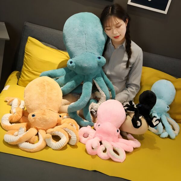 peluche-pieuvre-jaune-jouet-enfant-cadeau-original-mignon-2a Une jeune femme est assise sur un canapé avec quatre peluches pieuvres de différentes couleurs : bleu, orange, rose et noir.