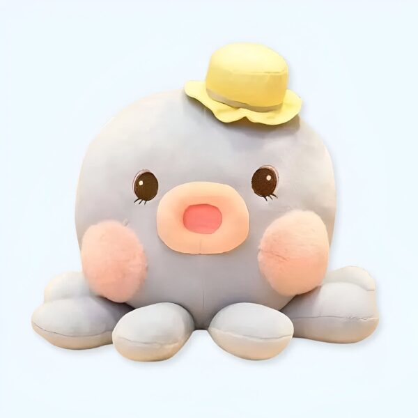 Une peluche de poulpe bleu avec un chapeau jaune, des joues roses et des yeux noirs.