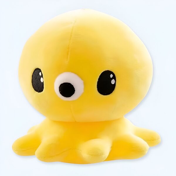 Une peluche jaune en forme de pieuvre avec de gros yeux noirs et un nez blanc.