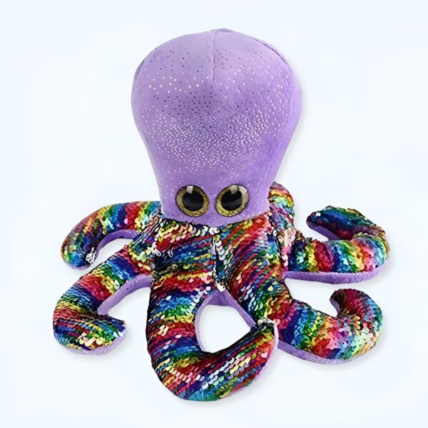 Une peluche de pieuvre violette avec des yeux globuleux et des tentacules arc-en-ciel recouverts de paillettes.