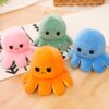 peluche-pieuvre-reversible-emoji-heureux-en-colere-cadeau-enfant-6a Quatre poulpes en peluche avec des expressions faciales différentes. Le poulpe orange a un air fâché, le poulpe rose a un air contrarié, le poulpe vert est souriant et le poulpe bleu est heureux.