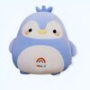 Une peluche de pingouin bleu avec un arc-en-ciel sur le ventre.