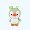 Une peluche de pingouin portant un costume de grenouille vert.