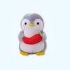 Peluche de pingouin gris tenant une carotte rouge.