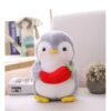 Un manchot en peluche gris tenant une carotte rouge.