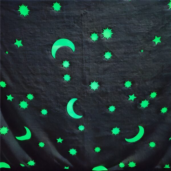 peluche-plaid-luminescent-etoiles-et-lunes-1a-1 Tissu foncé avec des étoiles et des lunes lumineuses en vert.