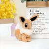 peluche-pokemon-evoli-et-aquali-pack-de-2-2a-2 Peluche Eevee marron et blanc assis sur une table blanche.