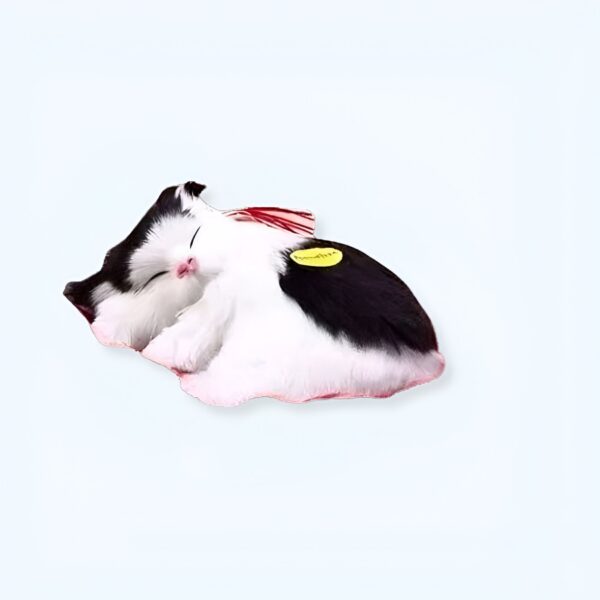 Un adorable chat noir et blanc en peluche endormi.