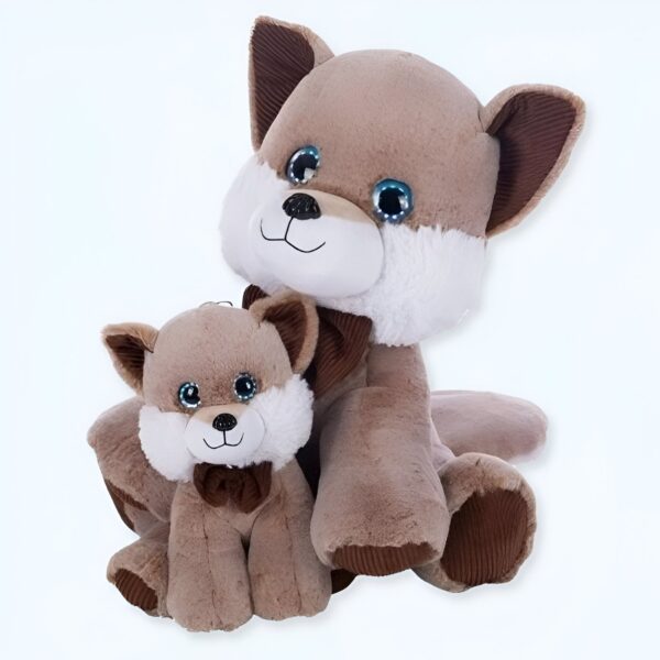 Deux peluches en forme de renard, une grande et une petite, assises l'une à côté de l'autre. Les deux peluches ont de grands yeux bleus et des nœuds marrons autour du cou.